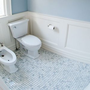 Compact bathroom with signs of water damage near the toilet and bidet area
